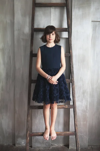 Menina adolescente em vestido preto agradável — Fotografia de Stock