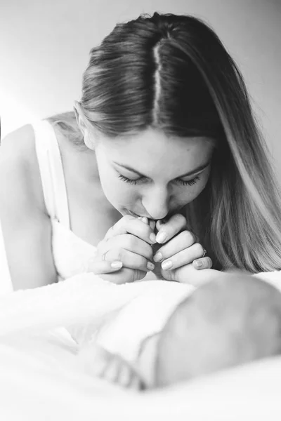 Женщина целует новорожденного ребенка — стоковое фото