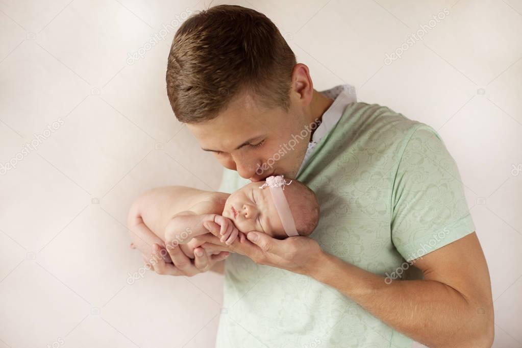 Daddy kissing  his newborn baby. 