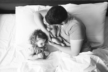 Baba küçük kızı yatakta ile.