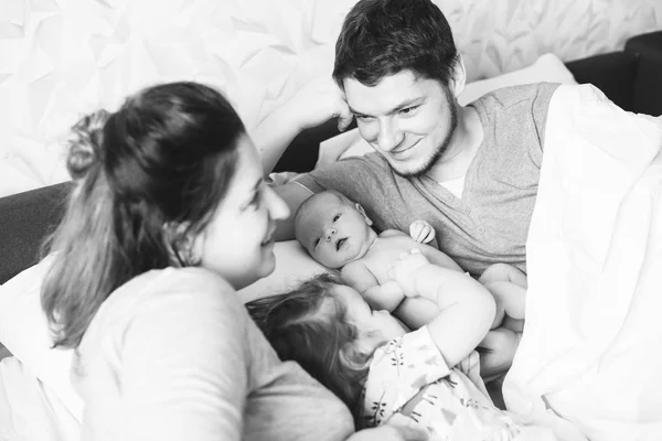 Οικογένεια με μικρά κόρες στο κρεβάτι — Φωτογραφία Αρχείου