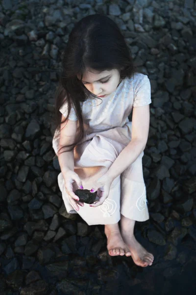 Niña sentada en las piedras — Foto de Stock