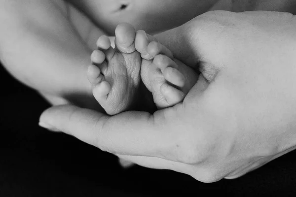 Маленькі дитячі ноги в руках матусі — стокове фото