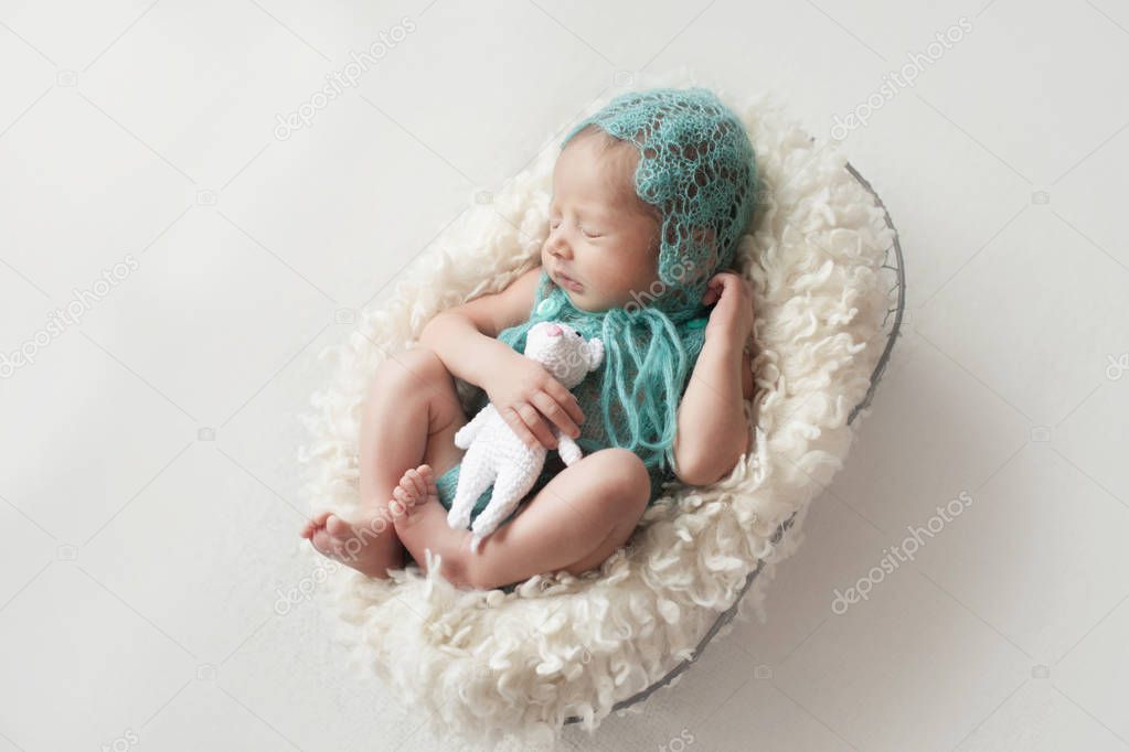 baby sleeping in a wire basket