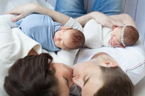 Родители держат новорожденных девочек и мальчиков — стоковое фото