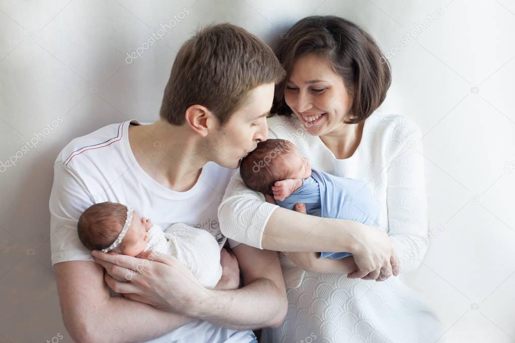 parents holding newborn girl  and boy