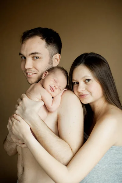 Família segurando recém-nascido adormecido — Fotografia de Stock