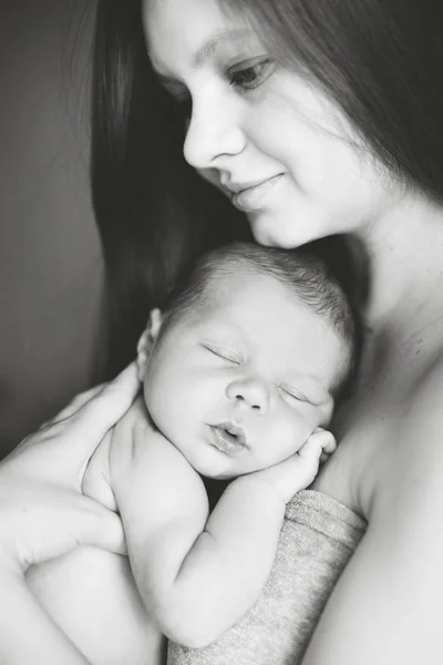 Мать держит спящего новорожденного сына — стоковое фото
