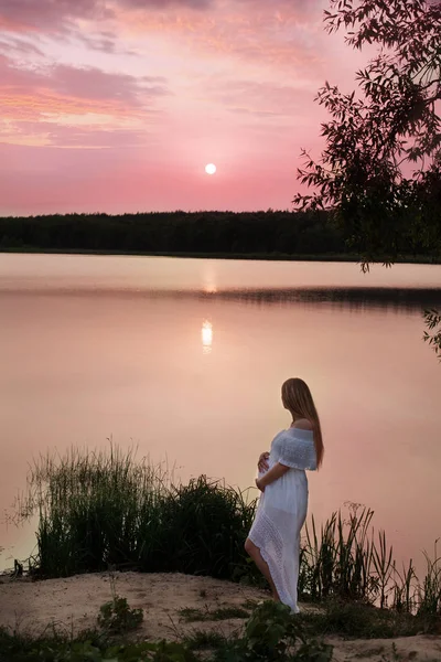 Mujer embarazada posando cerca del río — Foto de Stock