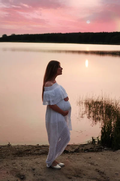 Těhotná žena pózuje u řeky — Stock fotografie