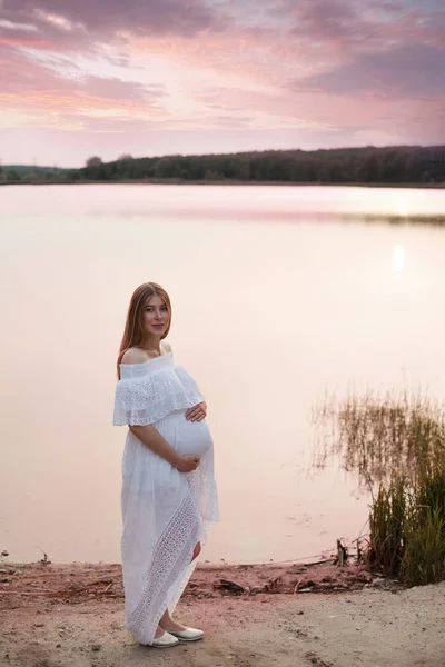 Těhotná žena pózuje u řeky — Stock fotografie