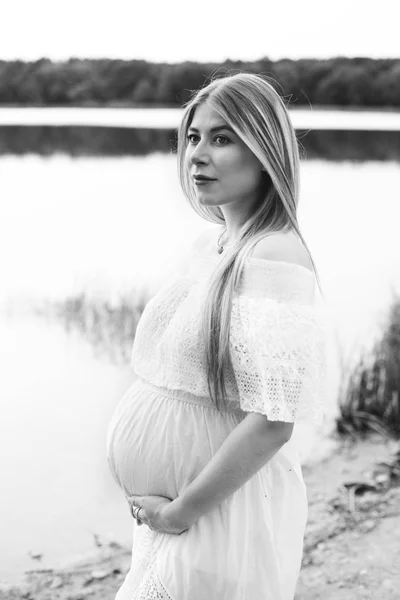 Mujer embarazada posando cerca del río — Foto de Stock