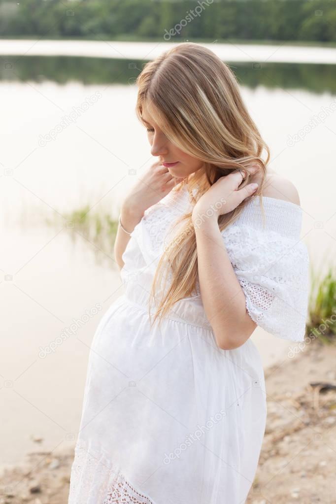 pregnant woman posing near the river