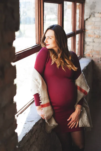 Zwangere vrouw in de buurt van het venster — Stockfoto