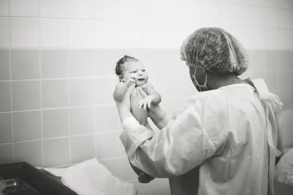 Доктор держит новорожденного ребенка — стоковое фото