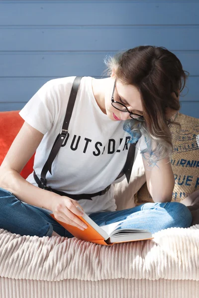 Chica inteligente joven esestudiante que estudia diligentemente en casa cerca de la ventana grande. Balcón, sofá, almohadas suaves —  Fotos de Stock