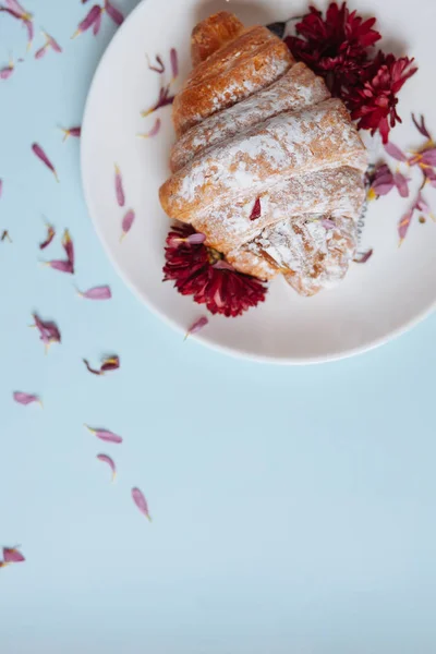 Croissant appena sfornato su un piatto bianco Immagine Stock