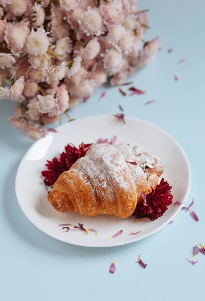 Nybakat croissant på en vit platta Stockbild