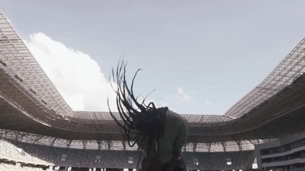 African-american girl play with her hair in the middle of stadium — Stock Video
