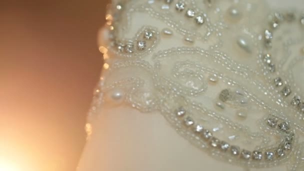 Крупный план из кристаллов и жемчуга, вышитого на свадебном платье — стоковое видео