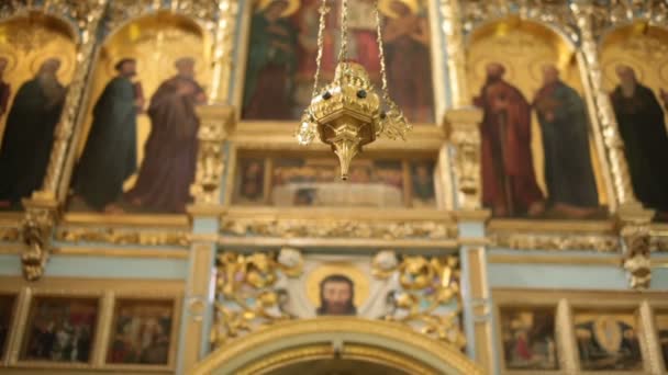 Gyllene lampa hänger på altaret i kyrkan — Stockvideo