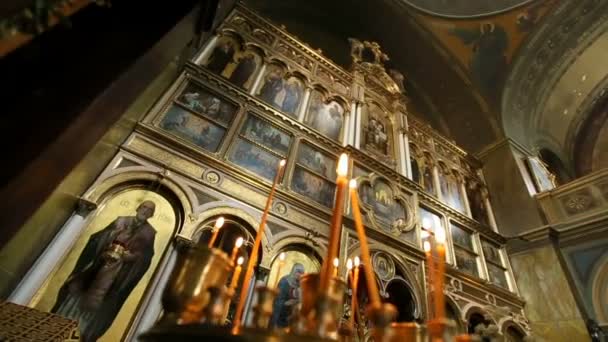 Kutsal kişilerin resmi üstünde belgili tanımlık duvar, parlak mumlar üzerinden bakmak — Stok video
