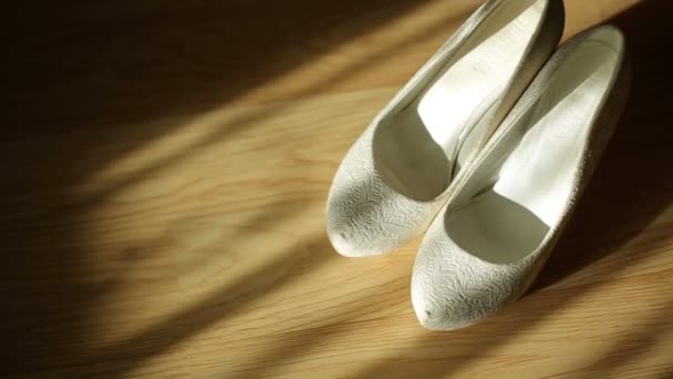 Morning light illuminates white shoes standing on the floor — Stock Video