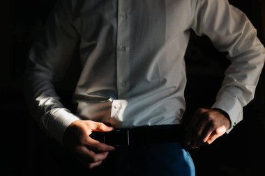 Adam onun kemer ayakta karanlıkta ayarlar