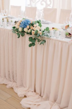 Küçük çiçek çelenk pastel pembe masa örtüsü üzerinde yatıyor