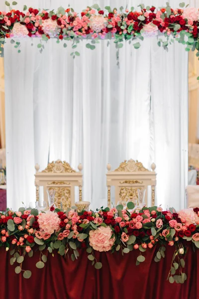 赤い花綱で飾られた豊かな食卓 — ストック写真