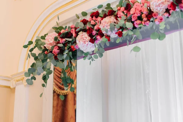 Grote bloem slinger van rode rozen hangt af van het venster — Stockfoto