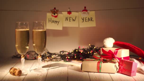 Szilveszter és a karácsony ünnepe a pezsgőt. Két fuvolára és szakadó gyöngyöző bort a palackból. Holiday dekorációk — Stock videók