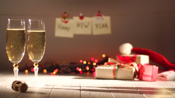 Celebración de Año Nuevo y Navidad con Champán. Dos flautas y vino espumoso de la botella. Decoraciones navideñas — Vídeos de Stock
