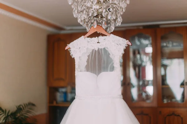 Vestido de noiva luxuoso pendurado no brilho no camarim — Fotografia de Stock