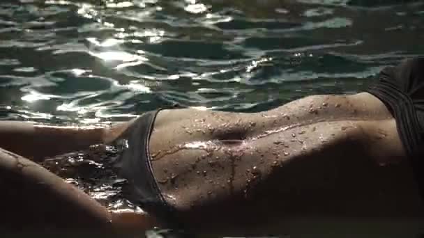 Jonge sexy aantrekkelijke vrouw in het water, close-up op de curven van het lichaam. Beauty concept. Druppels op lichaam, mooie huid — Stockvideo