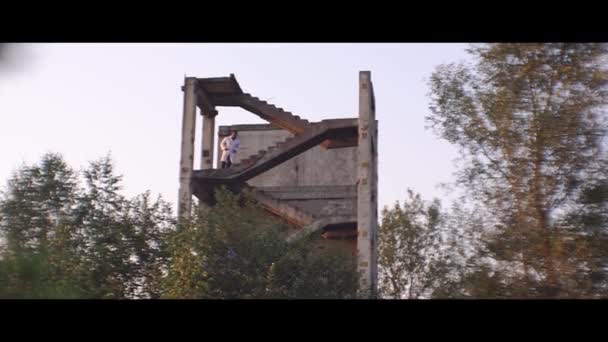 Чернокожий мужчина бежит по лестнице на развалины — стоковое видео