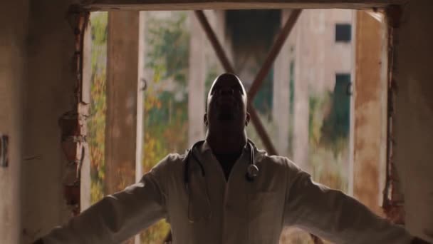 Сильный злой черный мужчина, стоящий в туннеле, поднимая руки вверх и крича, анаморфическая линза — стоковое видео