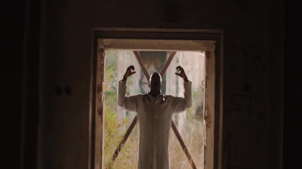 Сильный злой черный мужчина, стоящий в туннеле, поднимая и сжимая руки, крича, анаморфизмом — стоковое видео