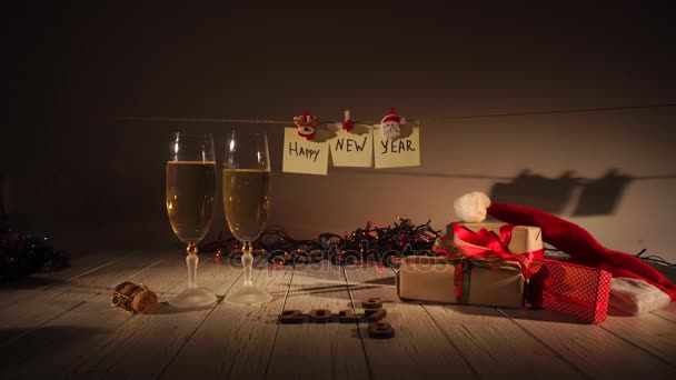 Nieuwjaar en Kerstmis vieren met Champagne. Twee fluiten en gieten mousserende wijn uit de fles. Decoraties voor de feestdagen — Stockvideo