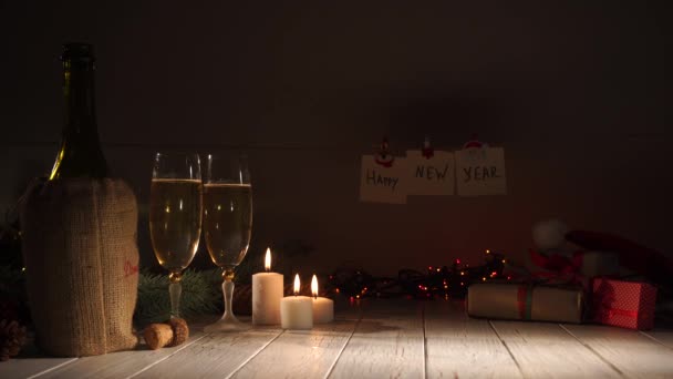 Το νέο έτος και Χριστουγεννιάτικη γιορτή με σαμπάνια και κεριά. Δύο φλάουτα και έκχυση αφρώδες κρασί από το μπουκάλι. Διακοσμήσεις διακοπών — Αρχείο Βίντεο