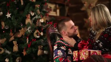 İki mutlu Sevgili Noel ağacının yanında oturan xmas kutluyor portresi