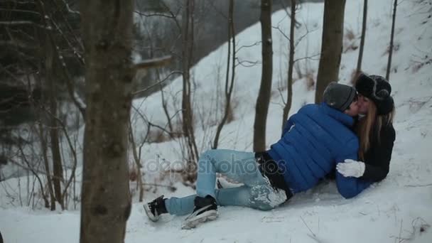 Hermosa pareja enamorada besándose en el bosque nevado de invierno — Vídeos de Stock