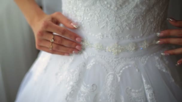 Невеста регулирует белое кружевное свадебное платье близко. Свадебная подготовка — стоковое видео