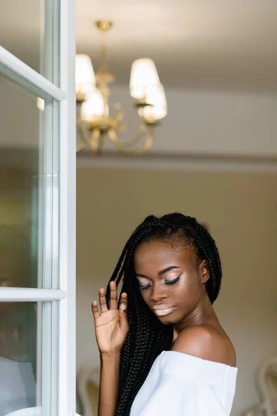 Mooi meisje met zwarte huid verblijft in VIP-ruimte van het hotel. Model opgemaakt van haar hand en haar ogen dicht. — Stockfoto