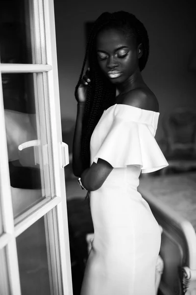 Black and white photo of african woman. Girl in white dress with white makeup and closed eyes — Stock Photo, Image