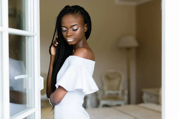 Foto di una donna africana attraente. Ragazza in abito bianco con trucco bianco e occhi chiusi — Foto Stock