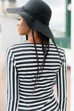 Geri Afrika model, siyah şapka ve çizgili şapka giyiyor.