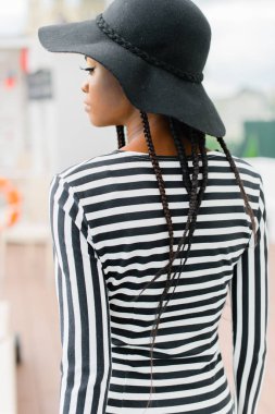 Geri Afrika model, siyah şapka ve çizgili şapka giyiyor. Koyu tenli ve kapalı gözler güzel kadınla.