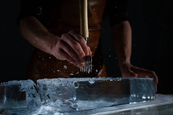 Бармен режет лёд специальным ножом. Павлины льдины ходят вокруг — стоковое фото