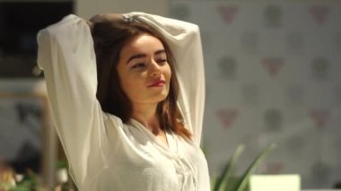 Mutlu kız sunlights üzerinde oturan ve kendini germe. Onun gözleri olmak zevk kapatın.